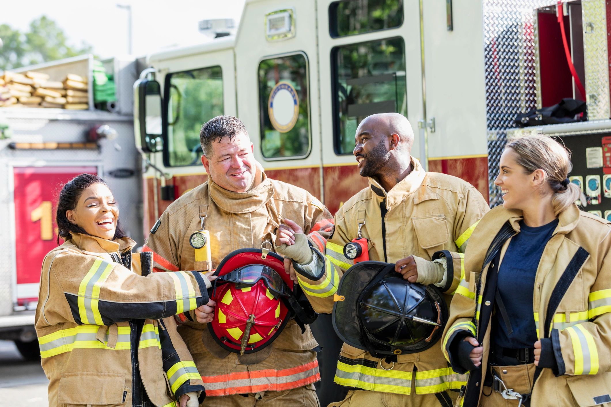Firefighters standing together in front of a fire truck