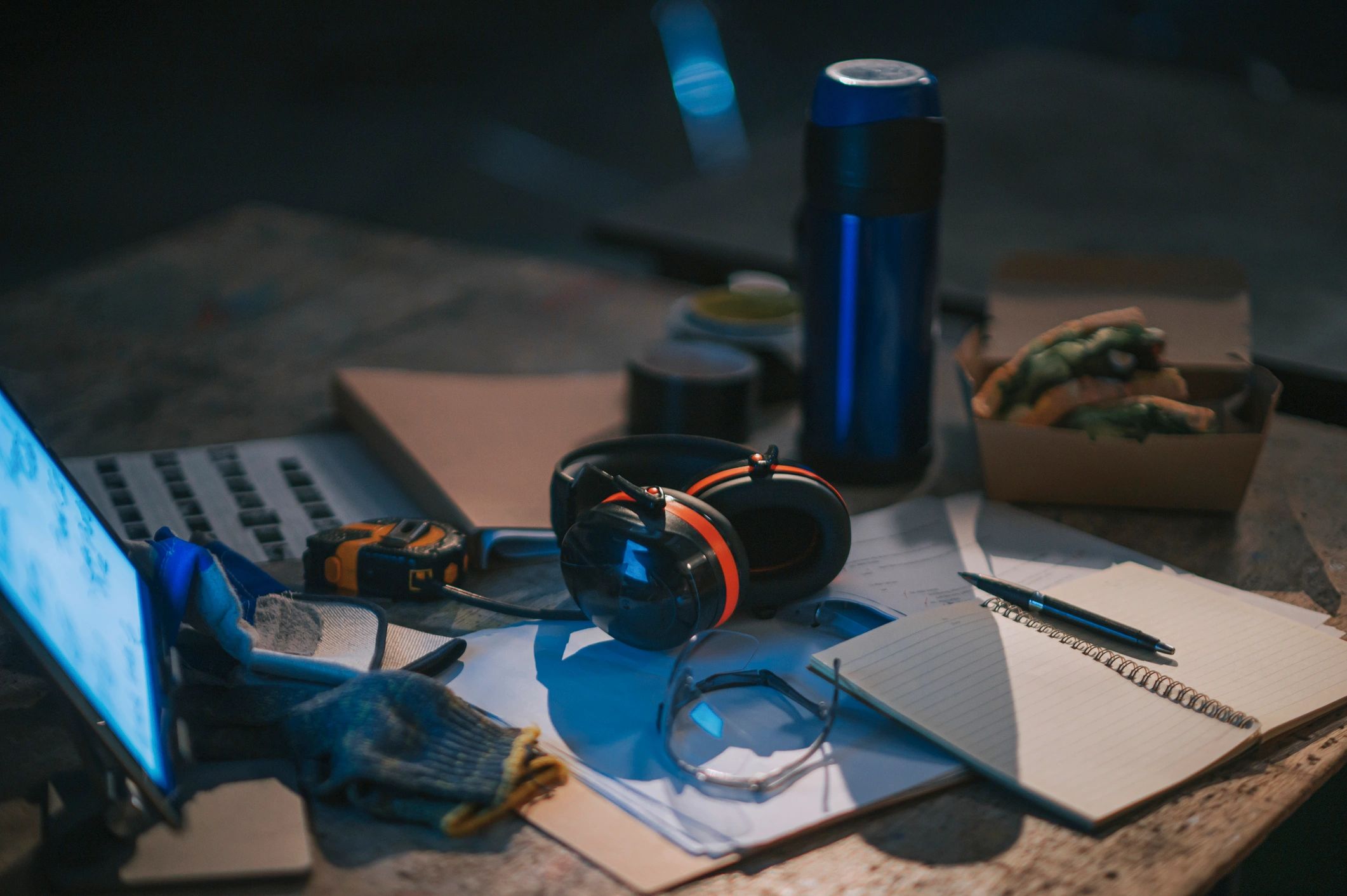 Safety gear and documents on a workbench table